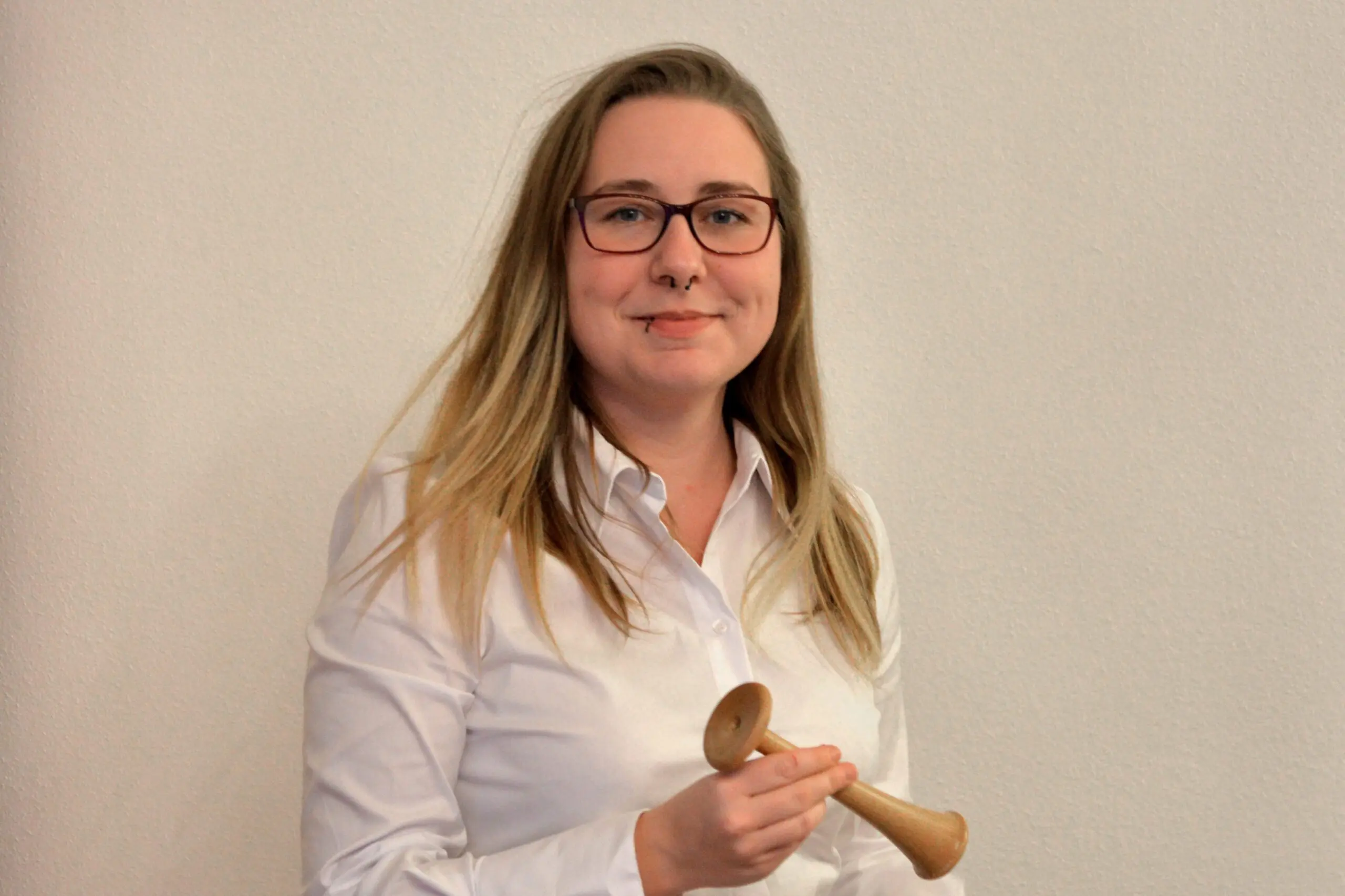 Hebamme Stephanie Bruckmüller mit einem hölzernen Hörrohr
